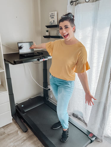 smiling woman on treadmill desk